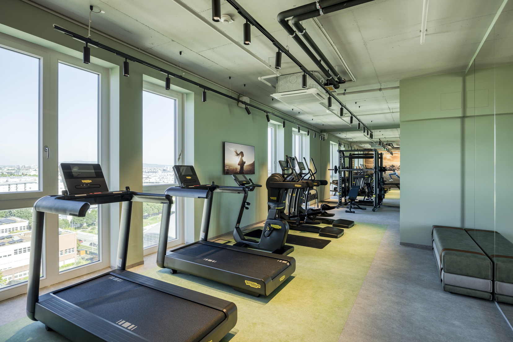Fitnessraum ausgestattet mit Laufbändern, Gewichten, Fahrrädern und Ellipsentrainern