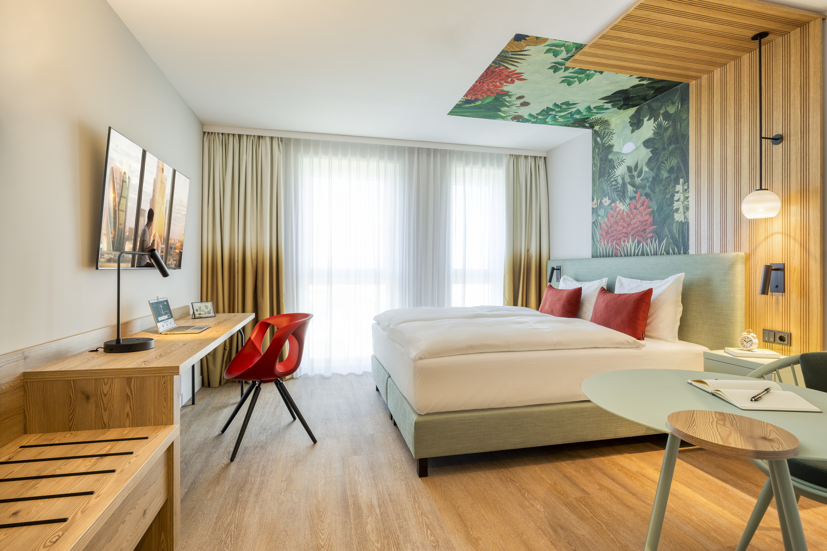 Studio mit einem Doppelbett, einem Fernseher mit Chromecast und einem Schreibtischbereich