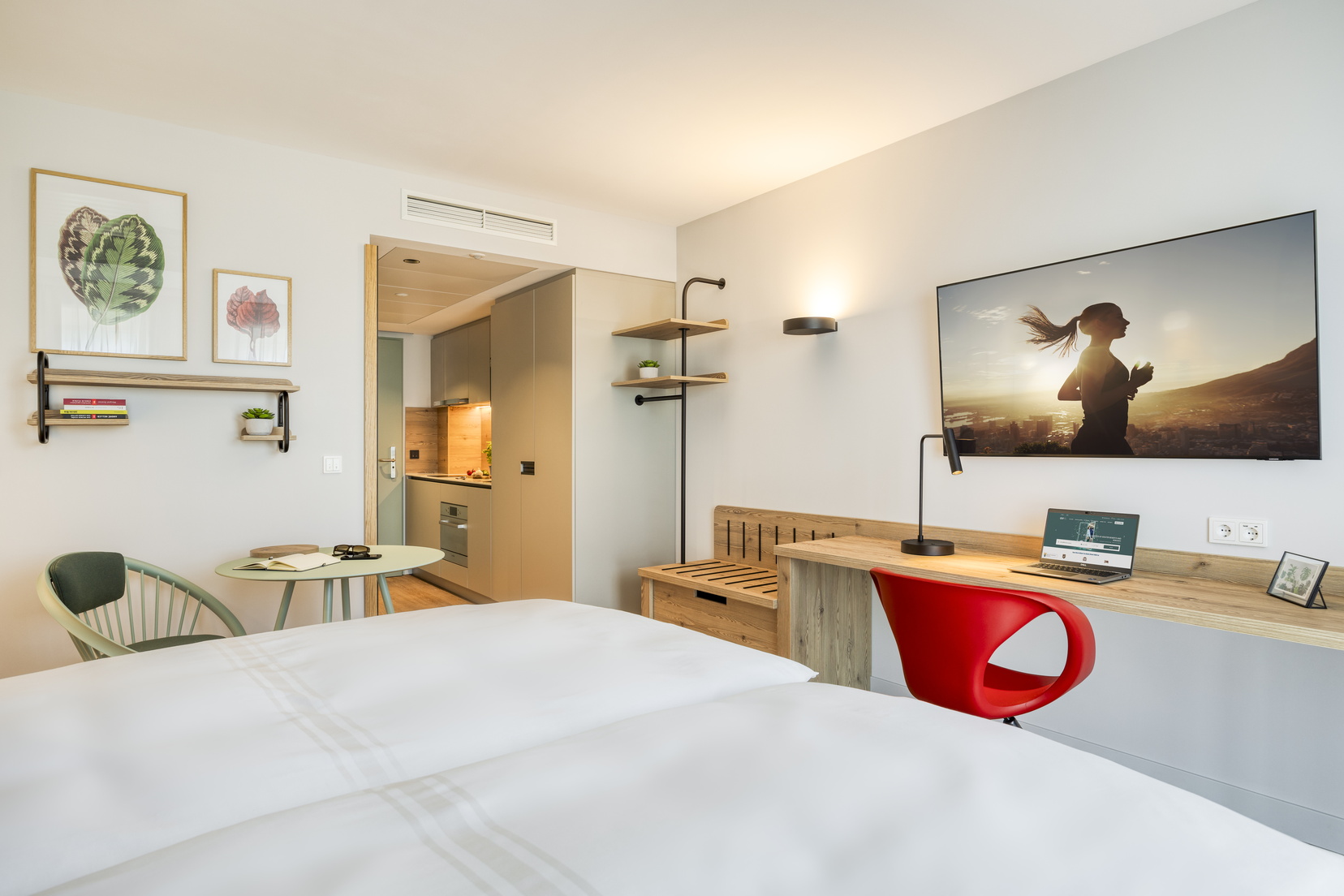 Studio mit einem Doppelbett, einem Fernseher mit Chromecast und einem Schreibtischbereich