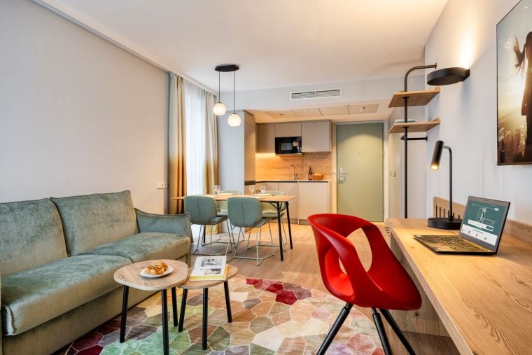 Wohnzimmer einer 2-Zimmer-Wohnung Executive mit Schlafsofa, Schreibtisch, Essbereich und voll ausgestatteter Küche