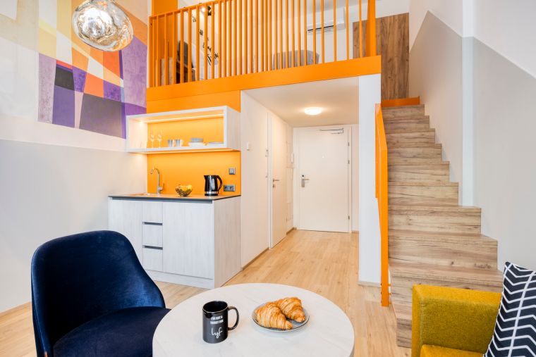 Wohnzimmer eines Level-Up Plus | Studios mit Kochnische und Schlafzimmer im Obergeschoss