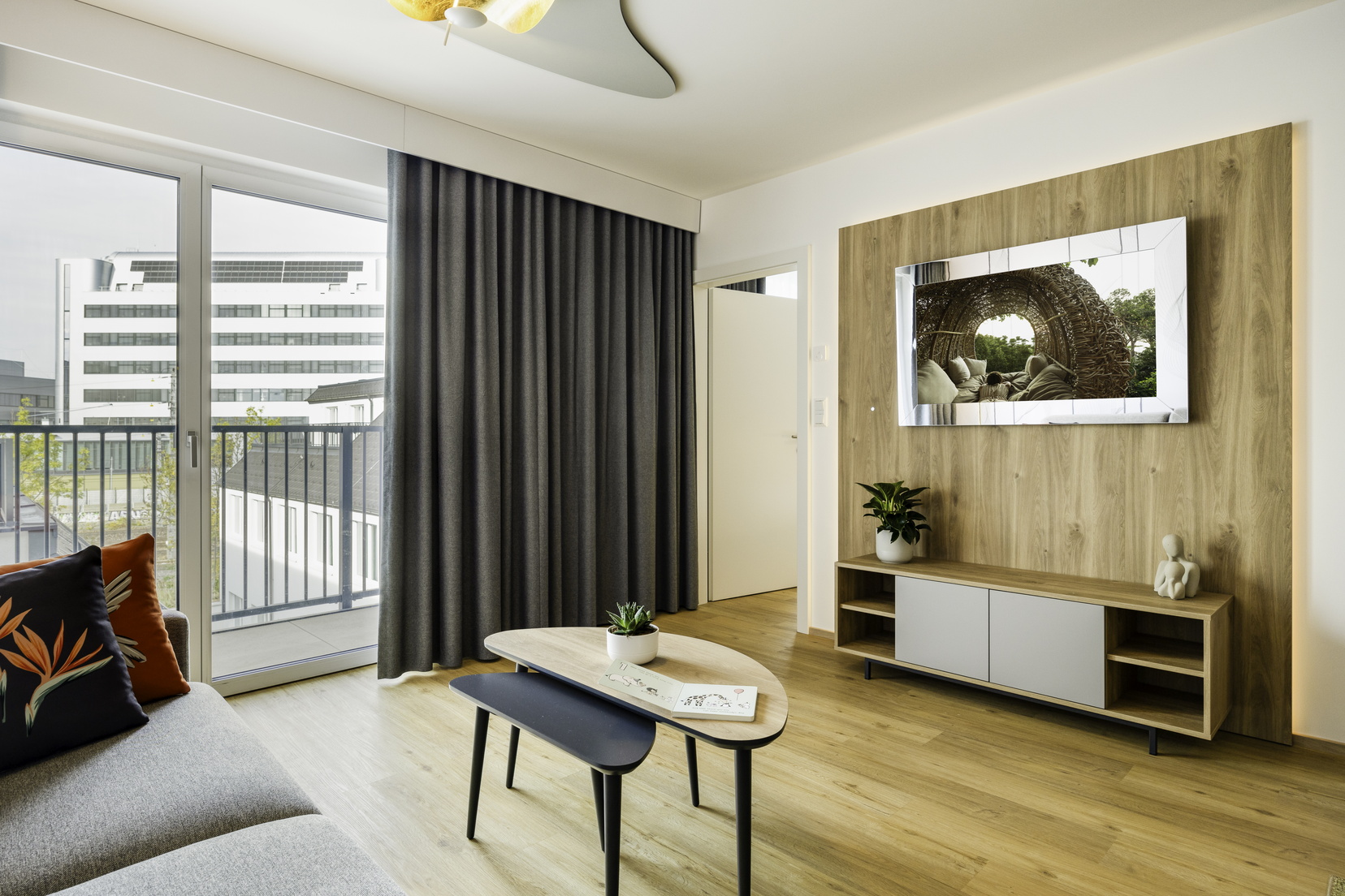 Wohnzimmer eines 3-Zimmer-Wohnung ausgestattet mit einer Küche, einem Schlafsofa und einem Fernseher mit Chromecast