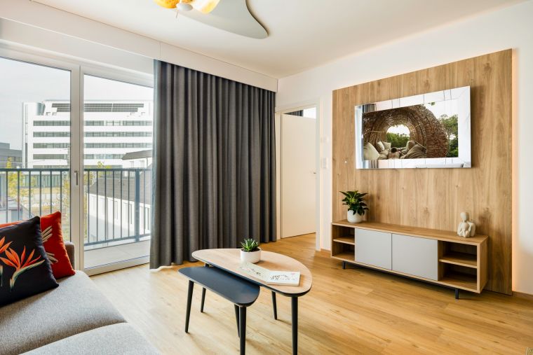 Wohnzimmer eines 3-Zimmer-Wohnung ausgestattet mit einer Küche, einem Schlafsofa und einem Fernseher mit Chromecast
