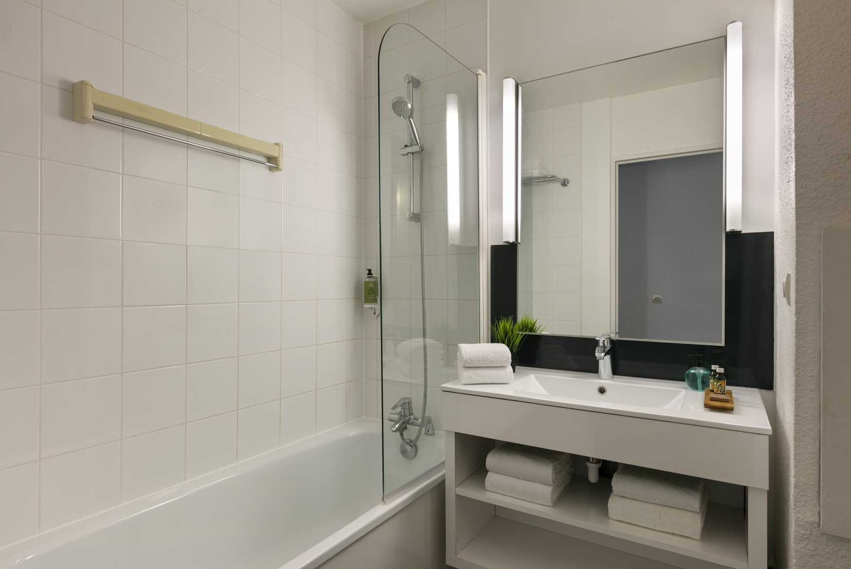 Salle de bain d'un Studio équipée d'un combiné baignoire/douche et de serviettes, appart hotel Paris 13