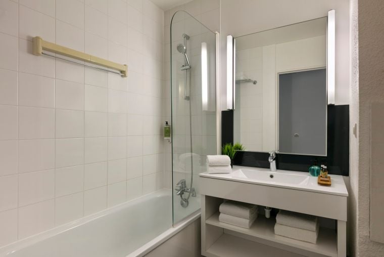 Salle de bain d'un Studio équipée d'un combiné baignoire/douche et de serviettes, appart hotel Paris 13
