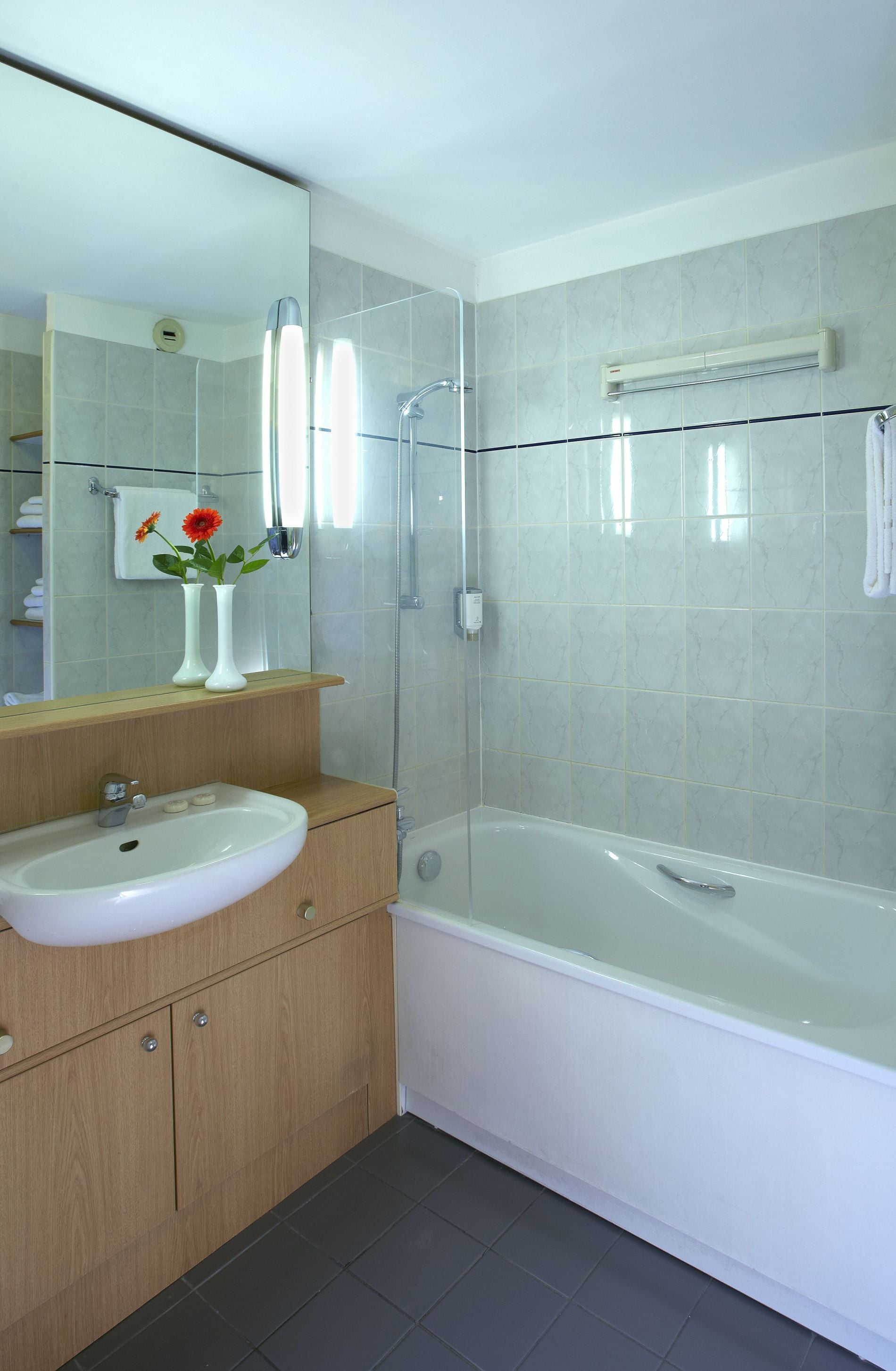 Bathroom of a Studio/Studio Deluxe equipped with a bath/shower combination and toiletries, apart hotel Paris 11