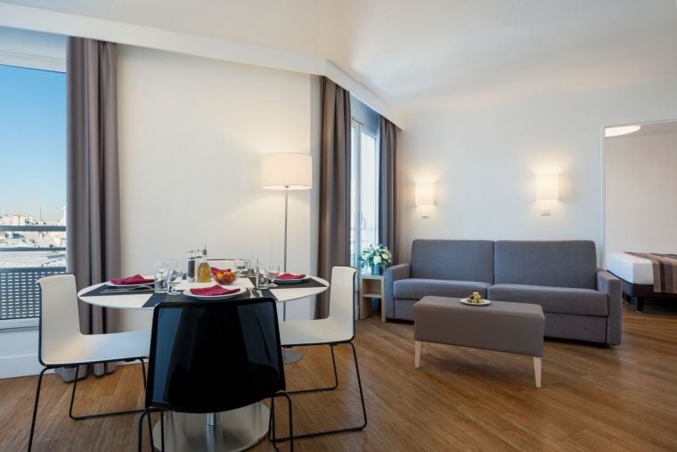 Living room of a 1-Bedroom Apartment with its sofa bed and its dining area, apart hotel Paris 11