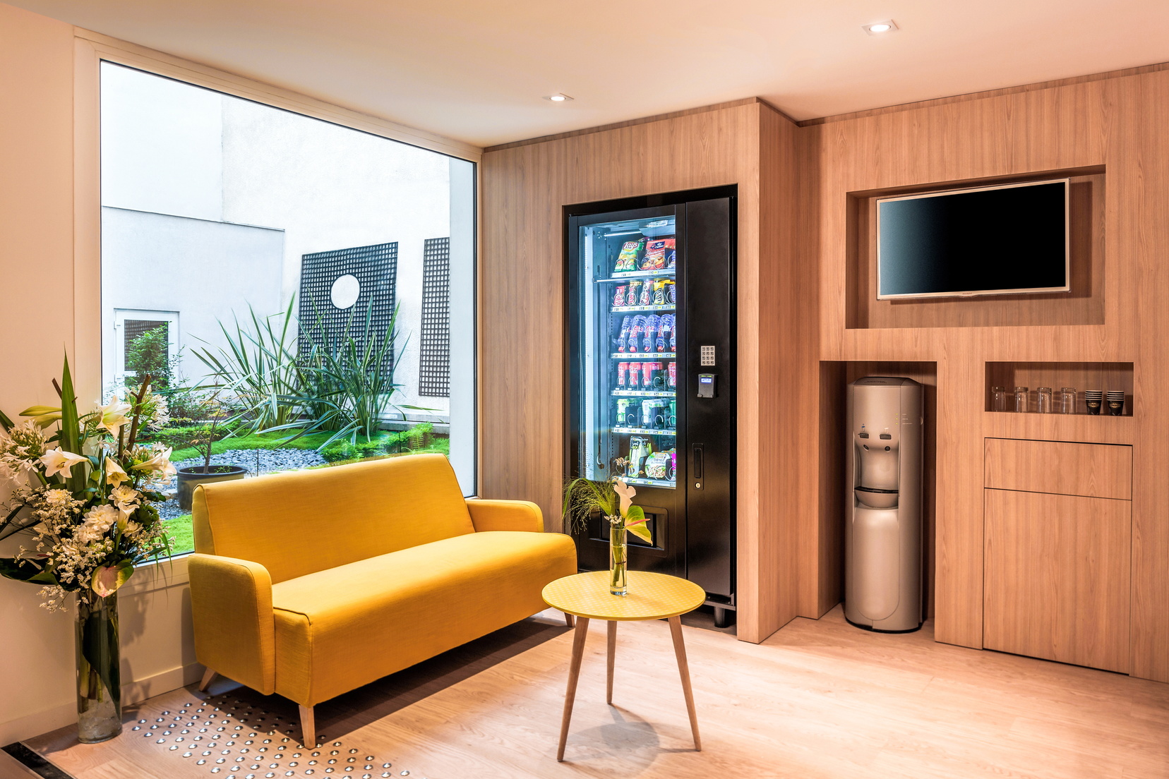 El salón de nuestro apart hotel en París 18 está equipado con una máquina expendedora y un televisor