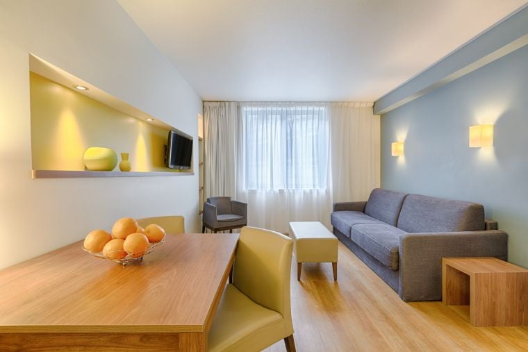 Living room of a 1-Bedroom Apartment equipped with a dining table, a television and a sofa bed, apart hotel Paris 13