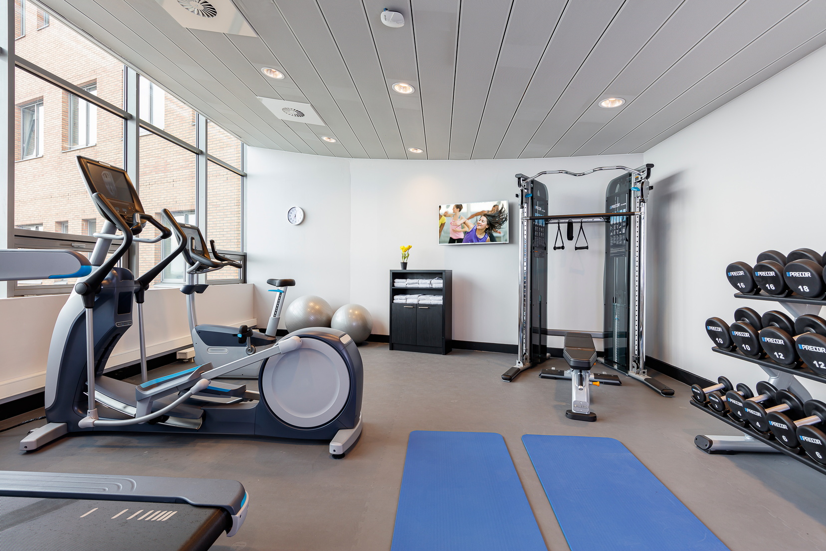 Gym with treadmills, weights, weight bench and elliptical bikes, apart hotel Amsterdam