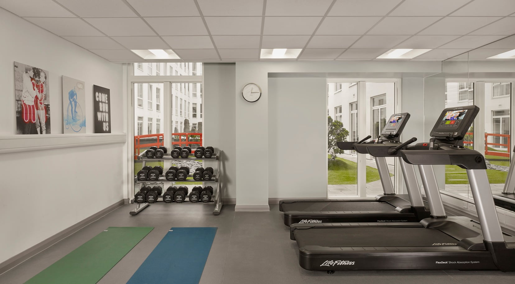 Sala de fitness con cinta de correr, colchoneta de fitness y pesas, apart hotel en Londres