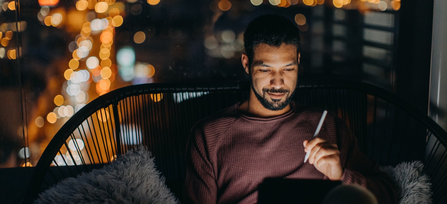 african american man balcony tablet night