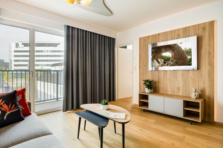 Living room of a 2-Bedroom Apartment equipped with a kitchen, a sofa bed, and a TV with Chromecast