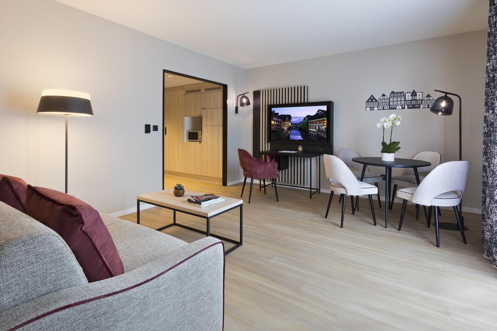 Salon d'un Appartement 2 pièces équipé d'un canapé-lit, d'un espace repas/bureau et d'une télévision, appart hotel Strasbourg